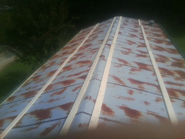 Rusted metal roof panels with new wood purlins before replacement — Storm Damage Roof Repair in Calamus by Roofing Brothers