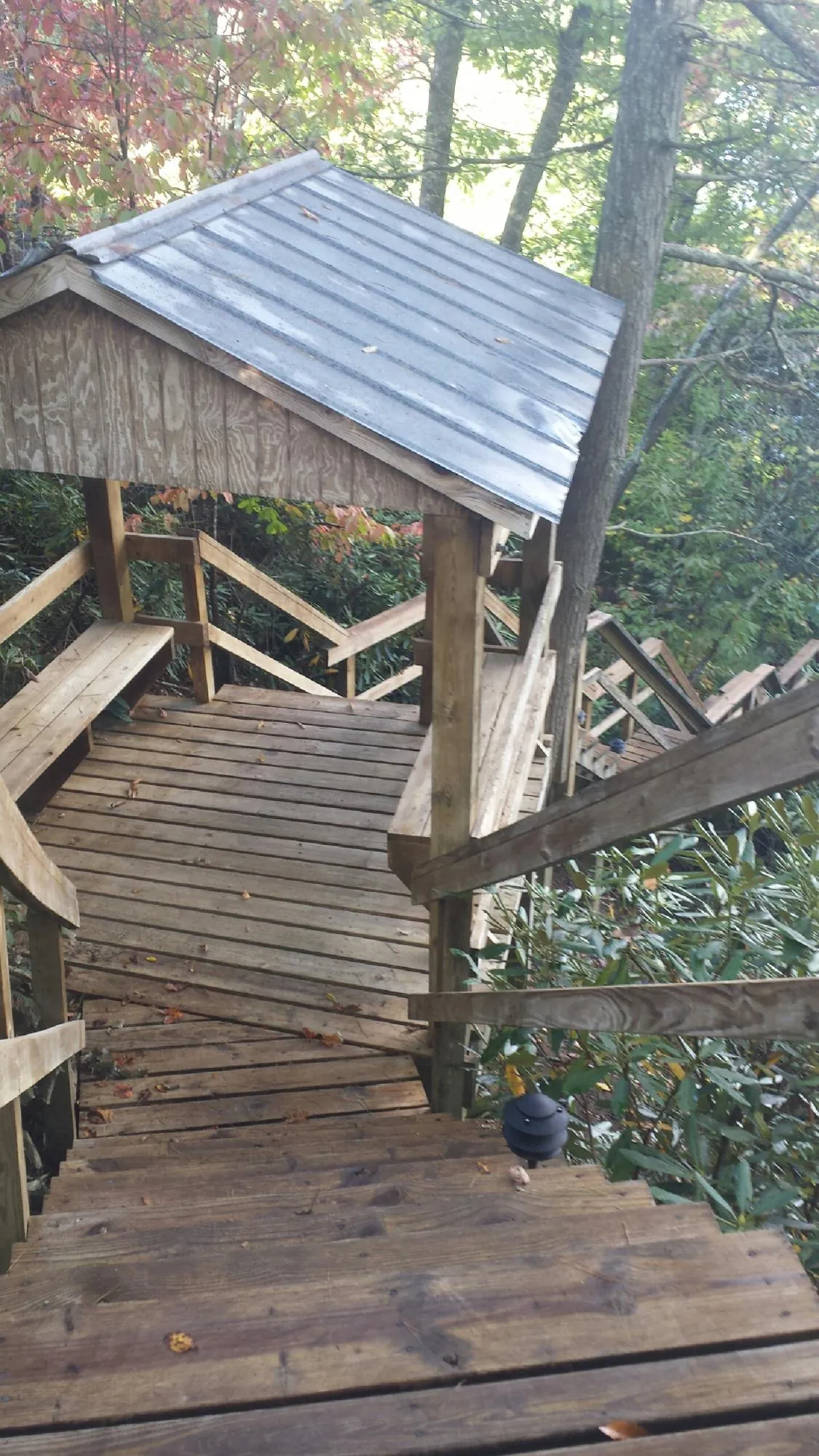 Metal roofed shelter over wooden steps on a wooded walkway — Skylight Repair & Installation work by our crew in Calamus